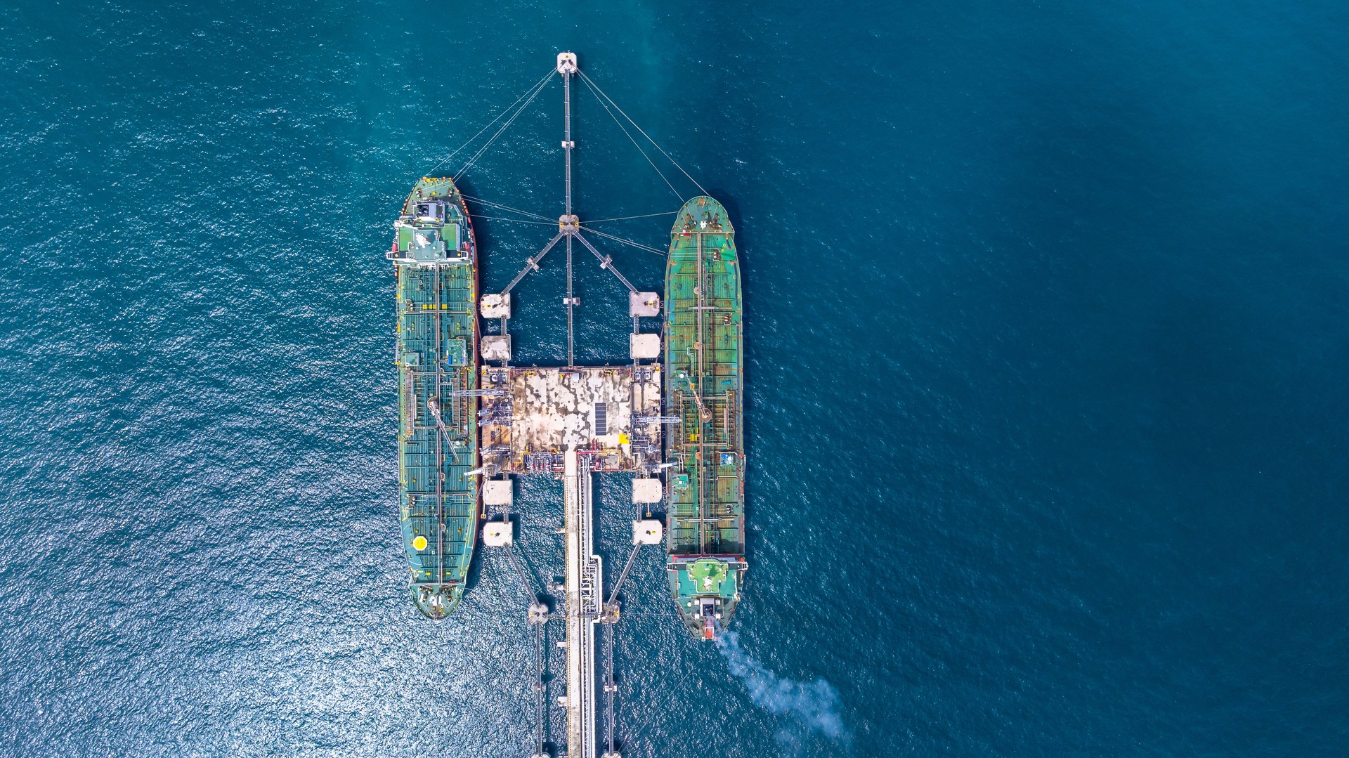 Aerial view oil tanker ship vessel loading and unloading in oil terminal station refinery, Global business import export logistic transport sea freight cargo tanker ship crude oil tanker ship at port.
